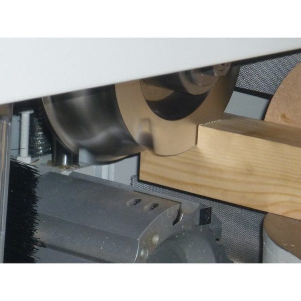 A wooden plank being processed in the Pentho Compact C3 Performance Tenoner